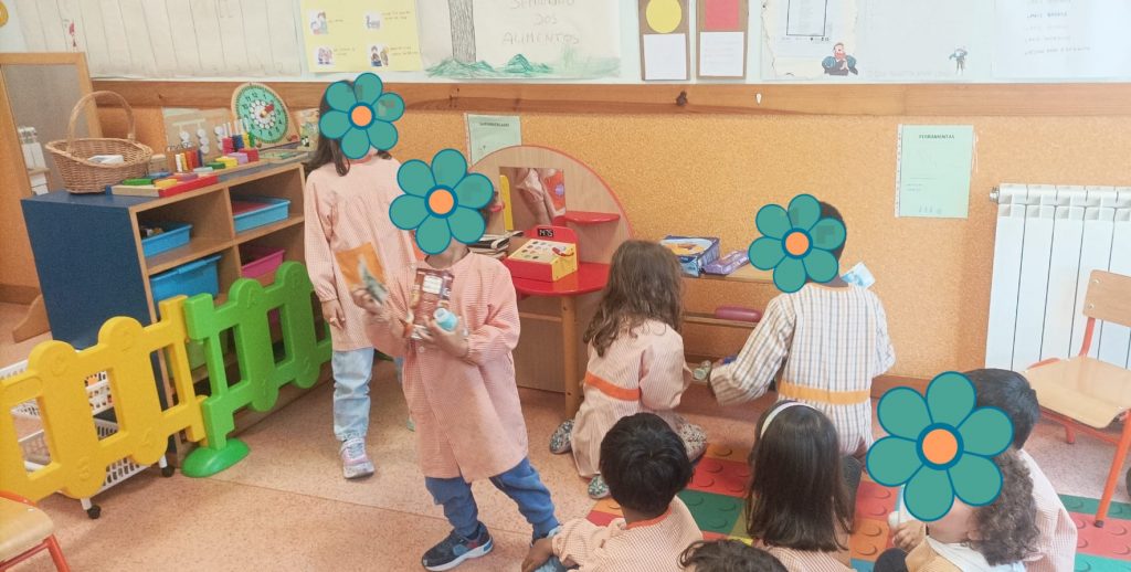 Grupo de crianças a interagir com artigos de supermercado de brincar